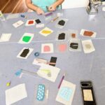 A table with various items on it, including a cell phone, a pair of scissors, and a pencil.