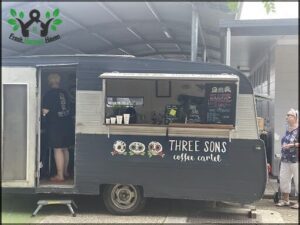 A Three Sons coffee cart is parked outside.