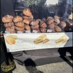 A variety of breads are displayed in a bakery, including sourdough toasts.