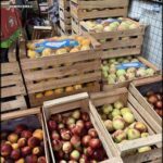 A variety of fruits, including apples and oranges, are displayed in wooden crates, ready for sale.