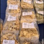 A variety of pasta is displayed in plastic bags.