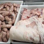 A variety of sausages and meats are displayed in a store.
