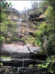 A waterfall cascades down a rocky cliff, creating a beautiful natural scene.