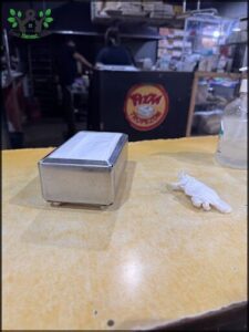 A white box with a white glove on top of it.