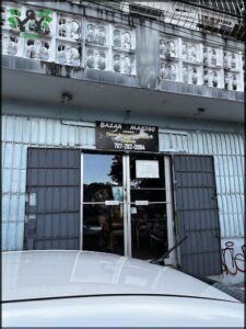 A white car is parked in front of a building with a sign that reads "Bazar Magasin."