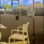A white chair sits in front of a tent, possibly at an outdoor market.