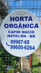 A white sign with blue writing that says "Horta Organica" on it.
