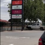 A white truck is parked in front of a sign for Virginia's Homes & Kitchens.