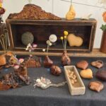 A wooden box filled with various items such as rocks, flowers, and nuts.