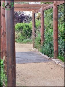 A wooden bridge with a thatched roof over it.