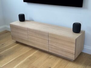 A wooden cabinet with two speakers on top.