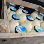 A wooden crate filled with cartons of milk.