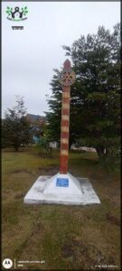 A wooden pole with a blue plaque on it.
