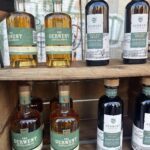 A wooden shelf with several bottles of Dewar's whiskey on display.
