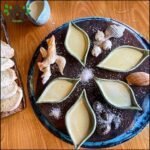 A wooden table with a plate of bread and a bowl of butter.
