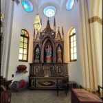 The interior of a church with a large wooden structure and stained glass windows.