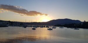 The sun is setting over a marina filled with boats.