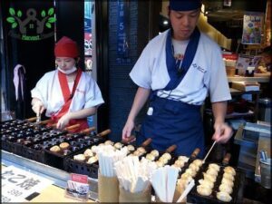 Two chefs are preparing food in a restaurant, with one chef on the left and the other on the right.