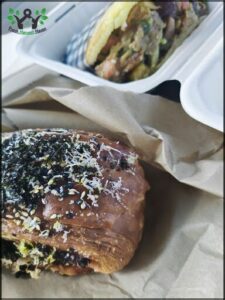 Two sandwiches, one with sesame seeds and the other with a different topping, are placed on a table.