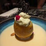 A bowl of cream with a fruit on top.