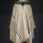 A brown and white striped blanket is draped over a mannequin.