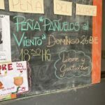 A chalkboard sign advertises a "Pena Panuelos al Viento" event.