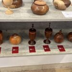 A collection of wooden vases and bowls are displayed on a shelf.
