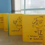 A collection of yellow books with drawings of people on them.
