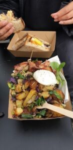 A delicious meal of ham, eggs, and potatoes is served in a box.