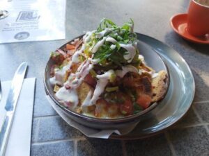 A delicious meal of nachos with white cheese and green onions.