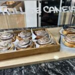 A display of pastries, including cinnamon rolls and donuts, are arranged on a table.