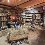 A display of various knick knacks and figurines, including a cow and a horse, is set up in a rustic cabin.
