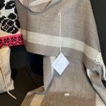 A gray and white striped blanket hangs on a wall.