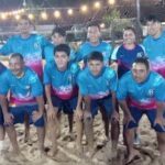 A group of men wearing blue shirts and shorts pose for a photo.