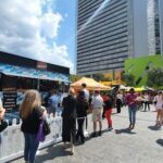 A group of people are gathered around a food truck, waiting to be served.