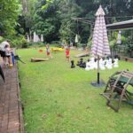 A group of people are playing chess in a backyard.