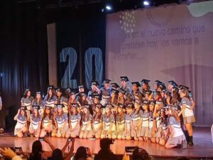 A group of students wearing caps and gowns pose for a picture.