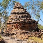 A large rock formation with a pointed top, resembling a beehive, stands out in the landscape.