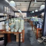 A large room filled with various pottery items, including vases, bowls, and cups.