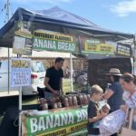 A man selling banana bread at a market.