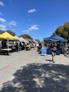 A man walks past a blue tent with a sign that says "Bluegum."