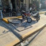 A motorcycle is parked next to a yellow ramp.