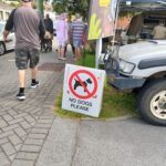 A "No Dogs Please" sign is placed on the sidewalk.