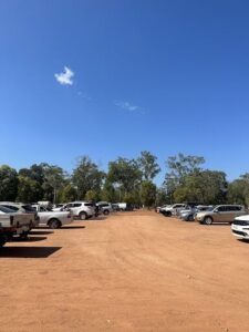 A parking lot filled with cars and trucks, with a clear blue sky above.