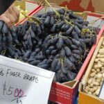 A person is holding a bunch of grapes in their hand.