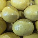 A pile of lemons are sitting in a bowl.
