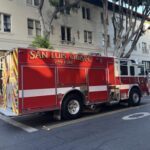 A red and white fire truck is parked in front of a building.