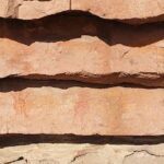 A rock wall with a red and white design on it.
