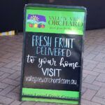A sign advertising fresh fruit delivered to your home.