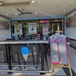 A sign advertising ice cream sits in front of a restaurant.